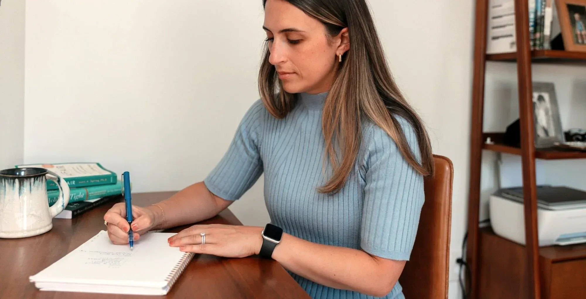 Cara Kraft, a therapist in Portland, Maine, writing notes at her desk